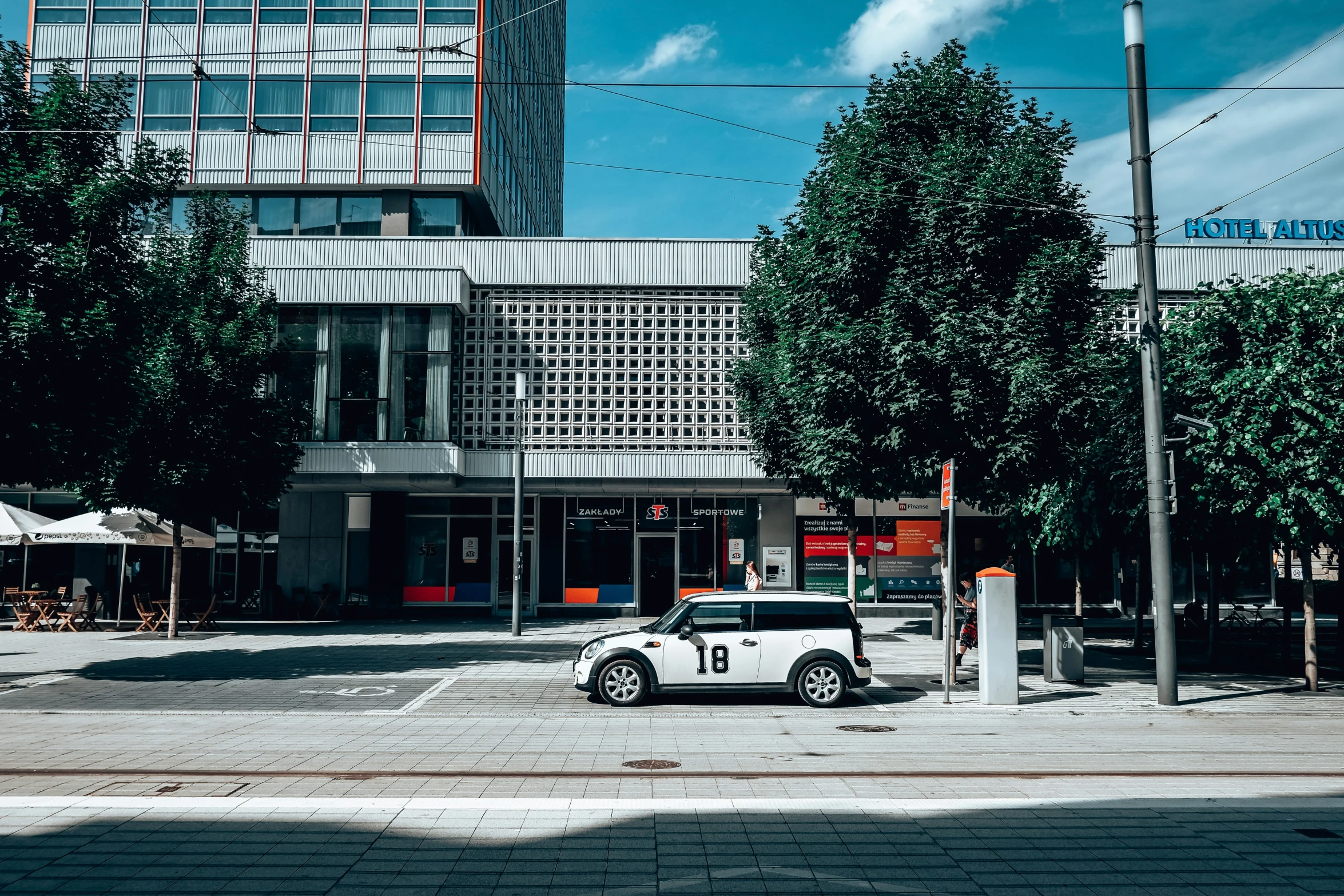 an intersection that has a car on it and several trees near it