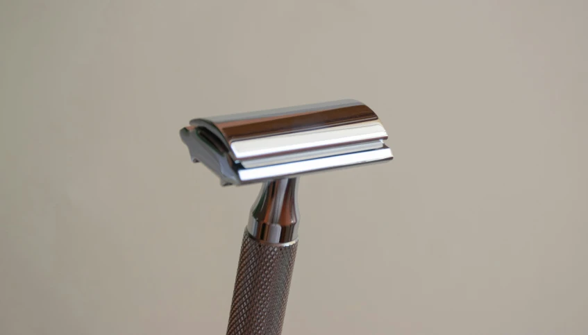 a pair of razor blades on top of a wooden handle