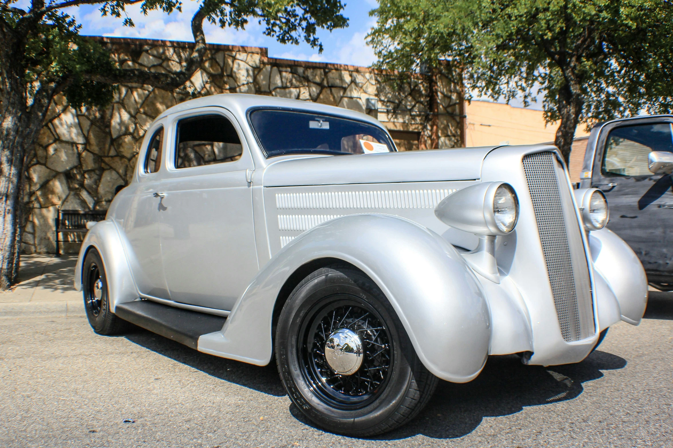 an antique white car sitting in a parking lot