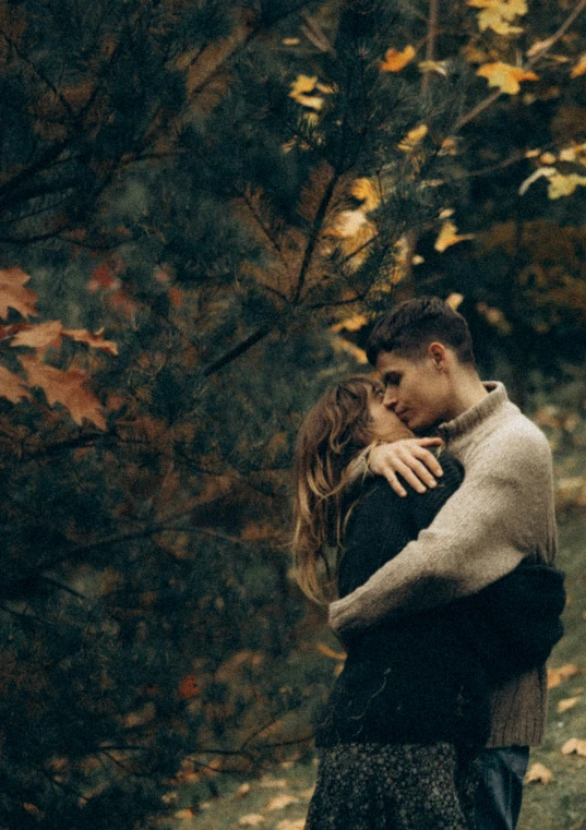 there are two people hugging each other in the woods