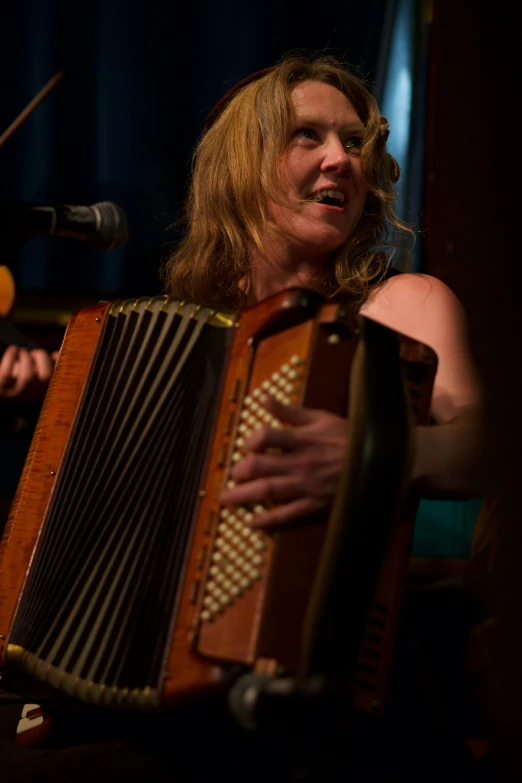 an image of a woman holding onto the hands of an accordion