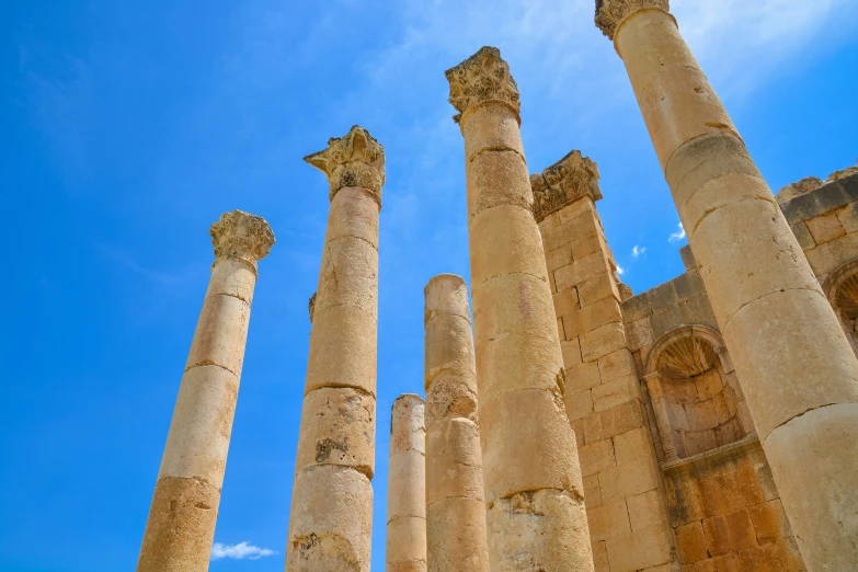 a few stone pillars stand under a blue sky