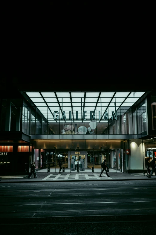 a night scene with the light of people walking outside a building