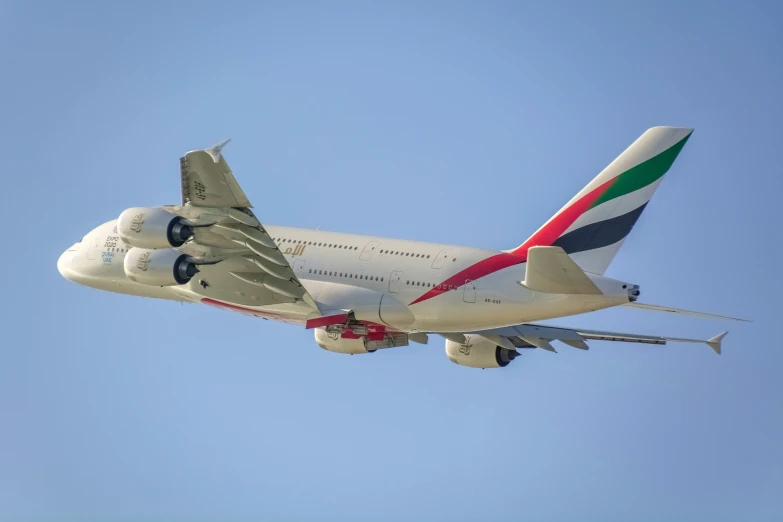 a white airplane is in the air on a sunny day