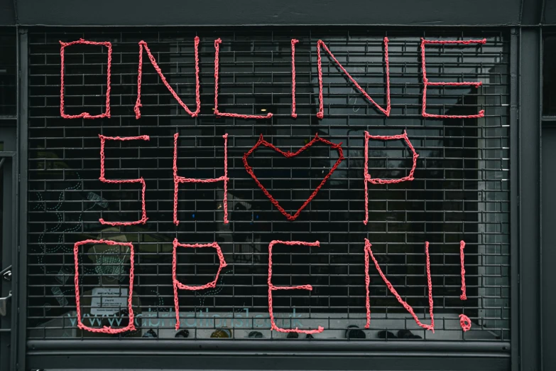 there is a sign that says online shop open on a storefront