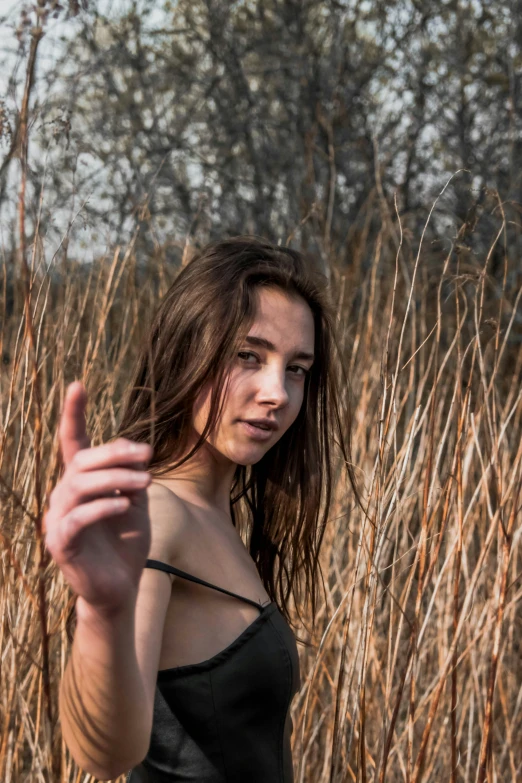 a young lady in a black outfit posing in tall grass