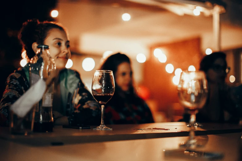 a couple of people sitting at a table with wine