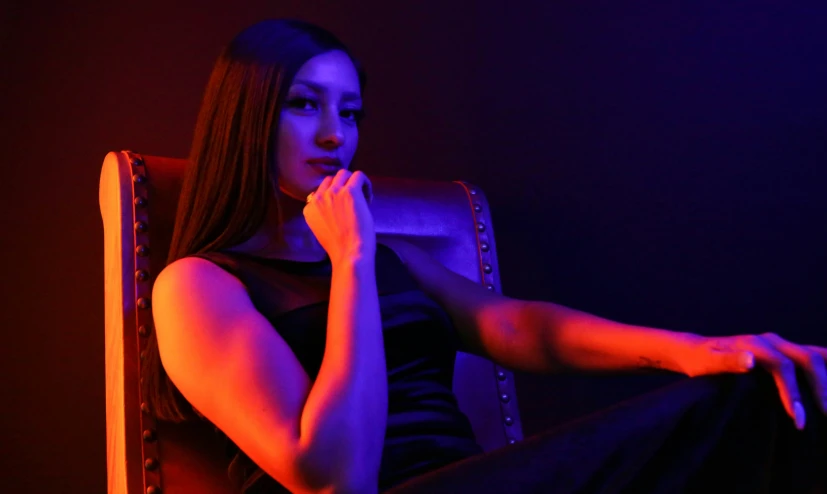 a girl sitting in a chair and posing