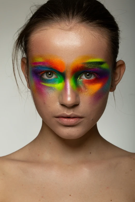 the woman is making colorful face paint as she poses