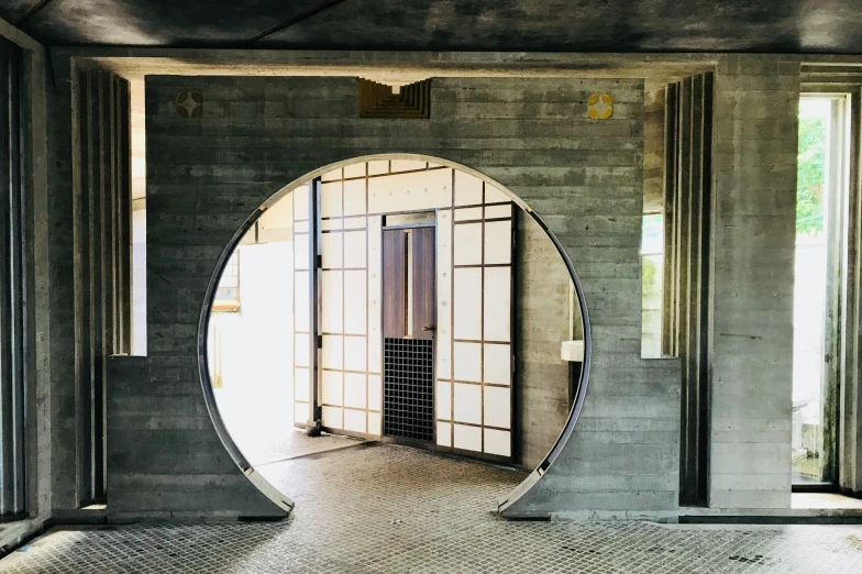 circular mirror on a wall reflecting a doorway