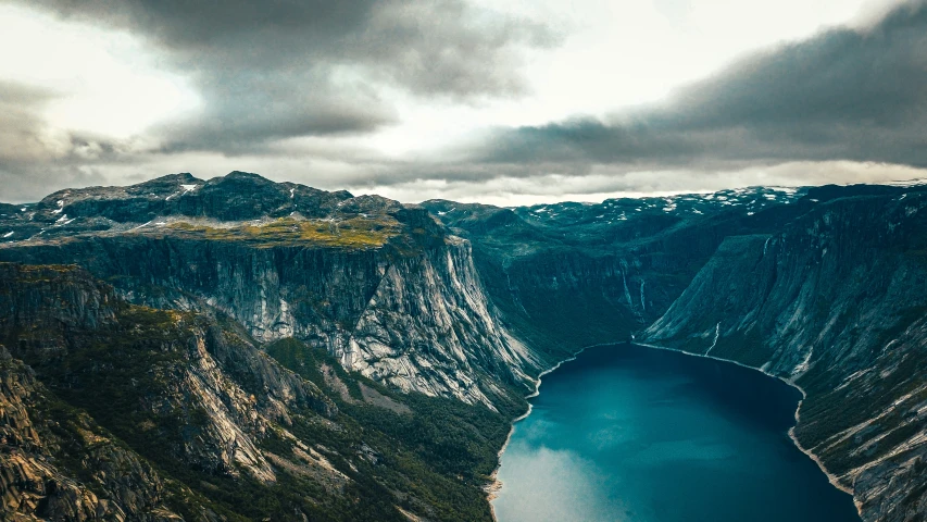 a view of a mountain top next to a lake and mountains