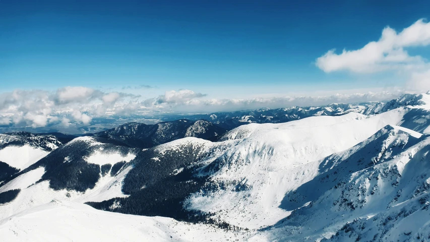 two mountain peaks are covered in snow and clouds