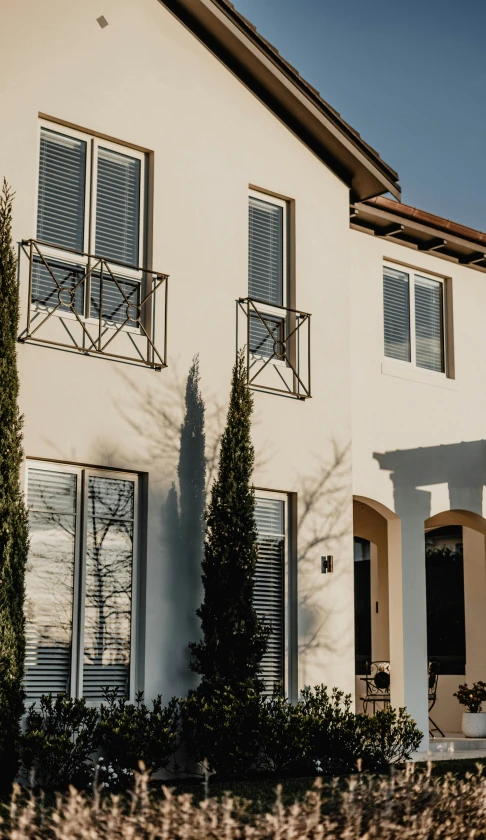 a house with some bushes and trees next to it