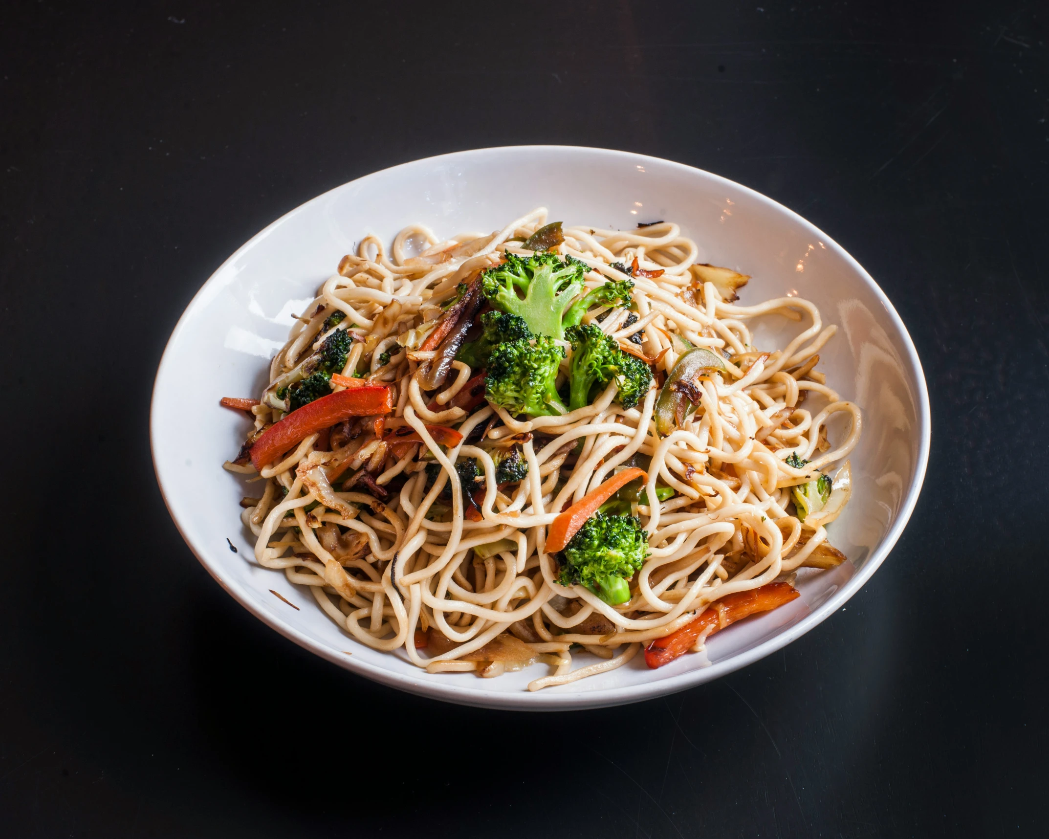 a white bowl full of noodles and vegetables