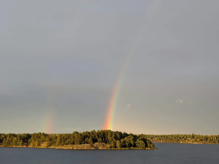 a boat is floating in the water near the tree covered island