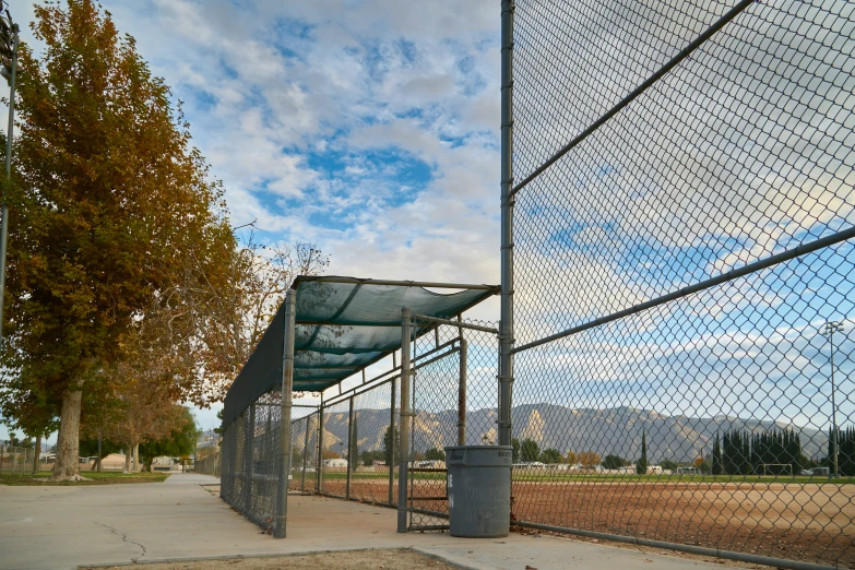 a batting cage on the side of a field