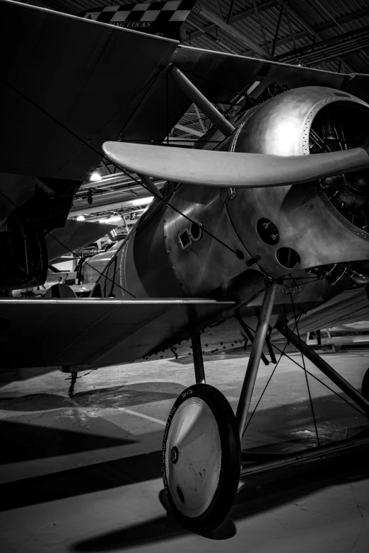 an old propeller airplane parked in a hanger