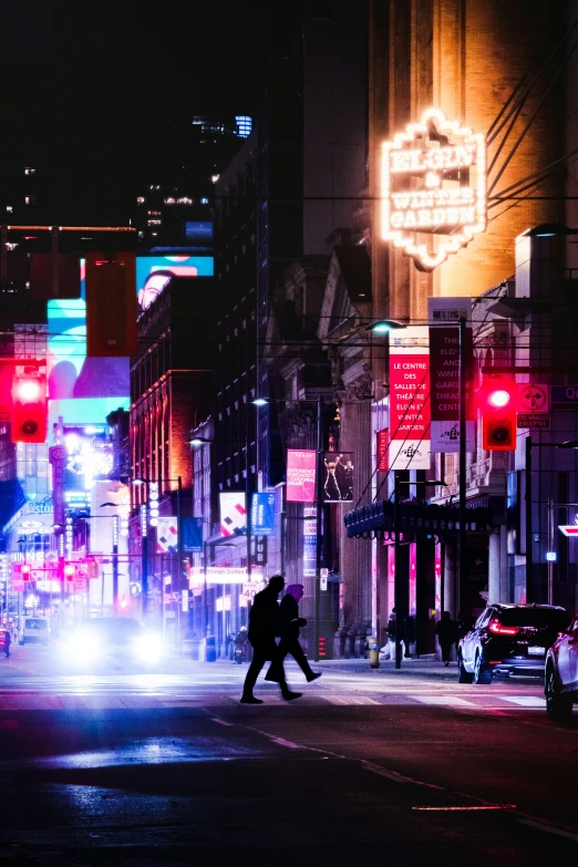 a city street has colorful neon signs along the buildings