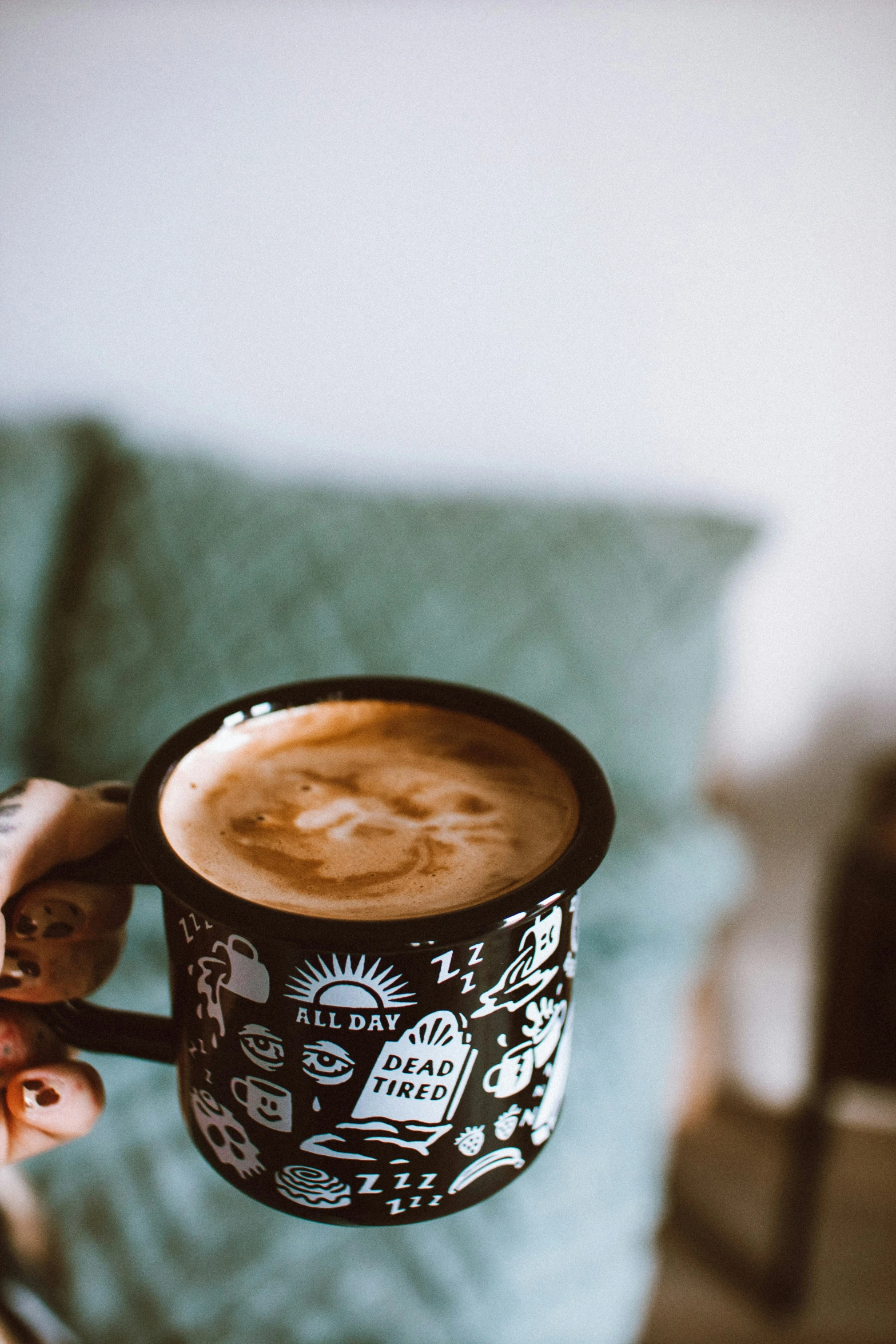 person holding a cup of  chocolate on top of a couch