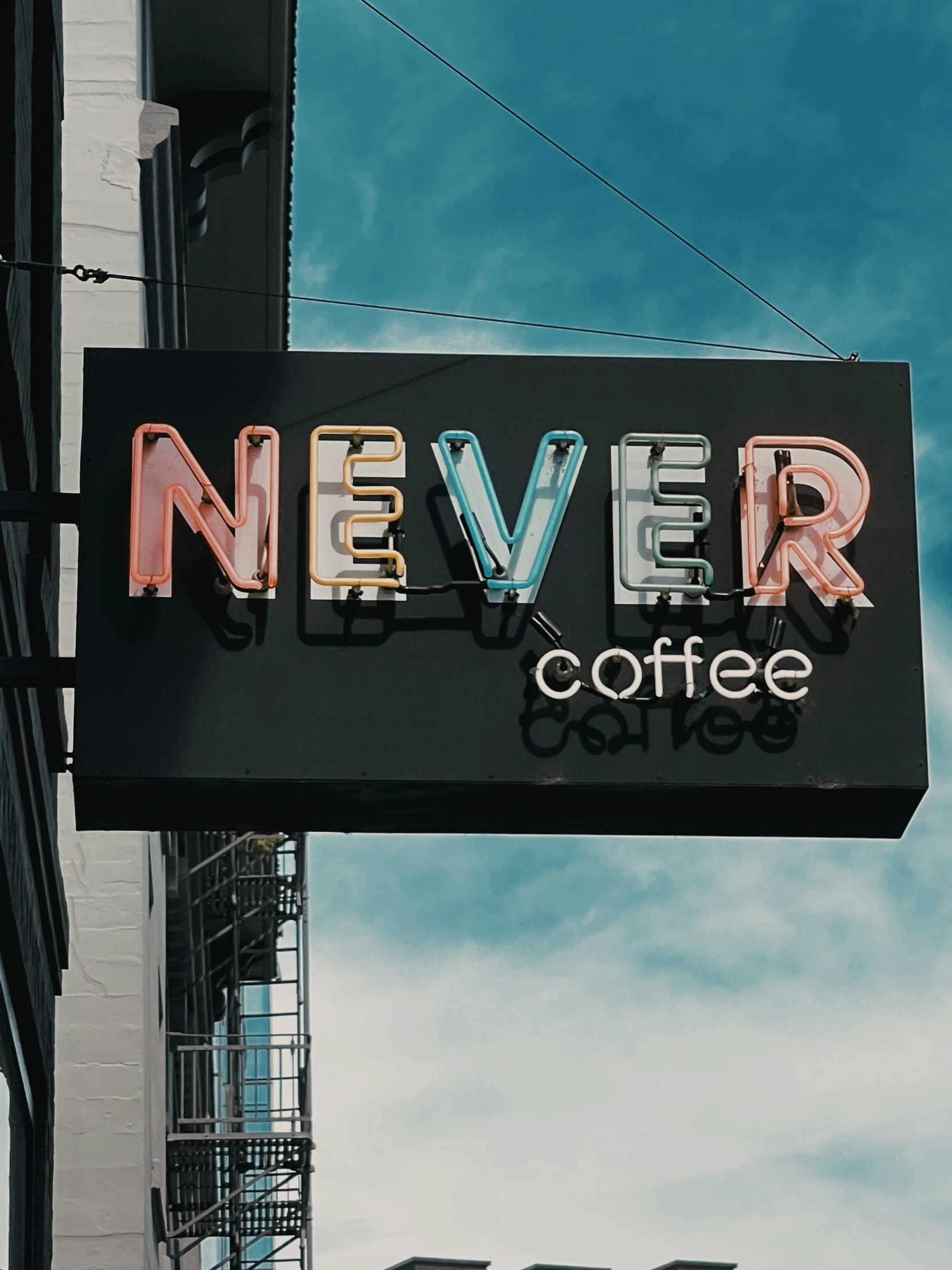 neon sign on the corner of a coffee shop