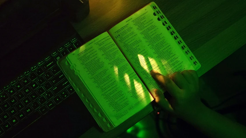 a person is illuminated by a computer book