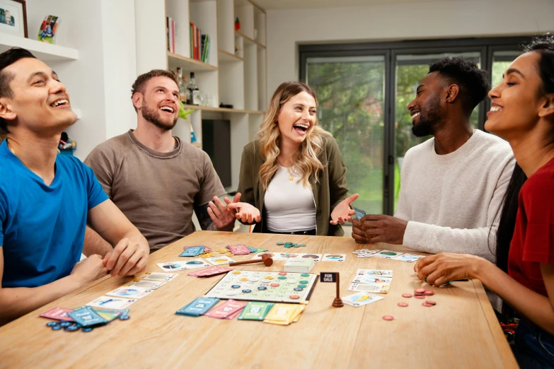 three men and two women play a game of cards