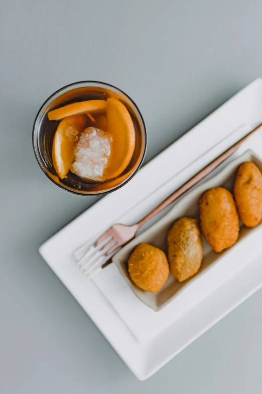 a white tray topped with three pieces of fried fruit