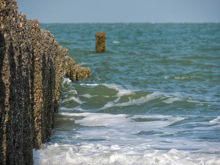 the waves are rolling against the rocks on the shore