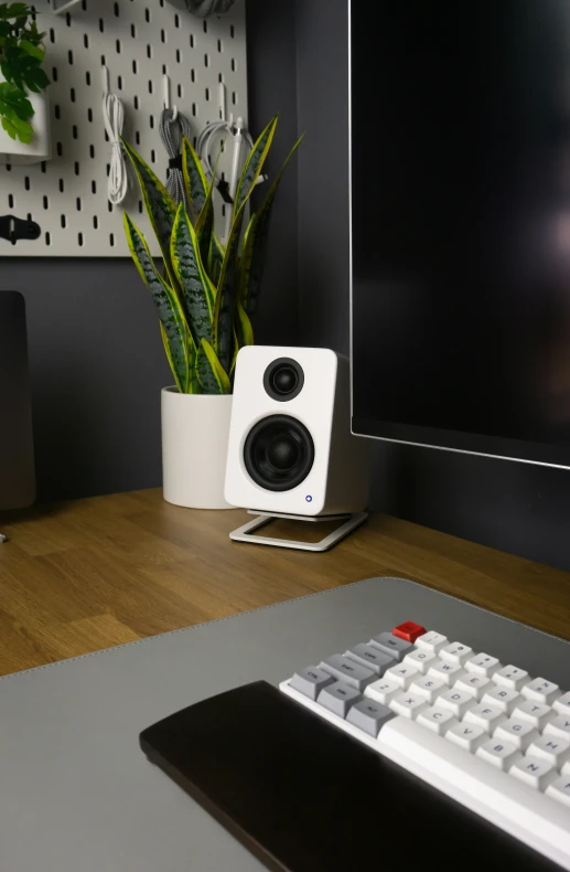 a white speaker is sitting on a desk