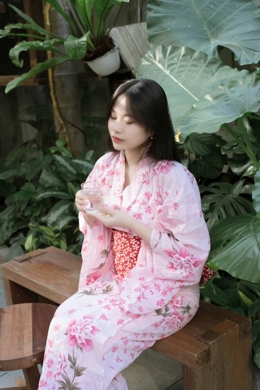 a woman is sitting on a bench in pink