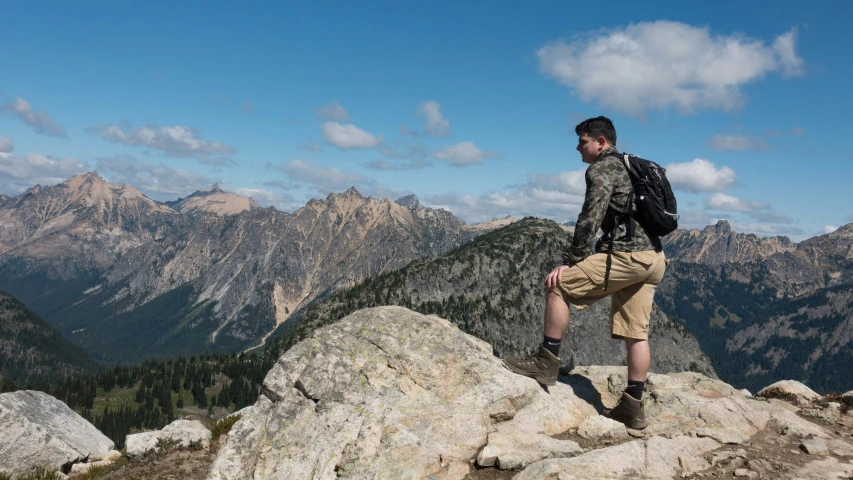 a man standing on a rock with his back turned