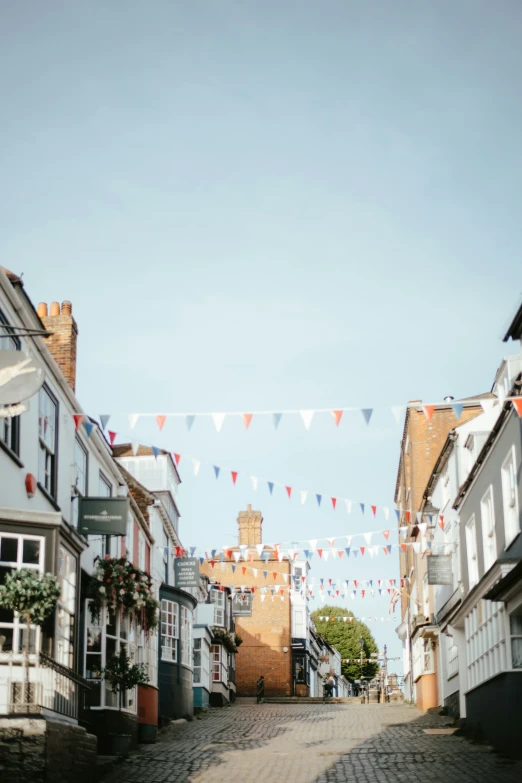 a narrow city street has little flags on it