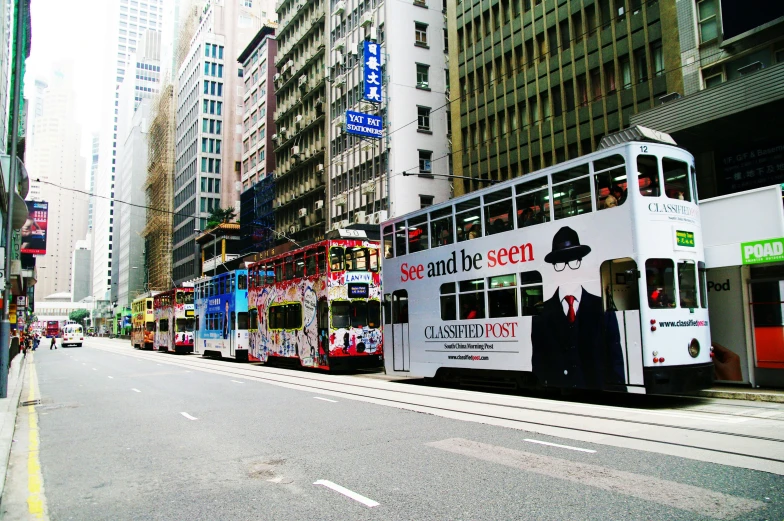 buses are parked on a narrow street in front of tall buildings