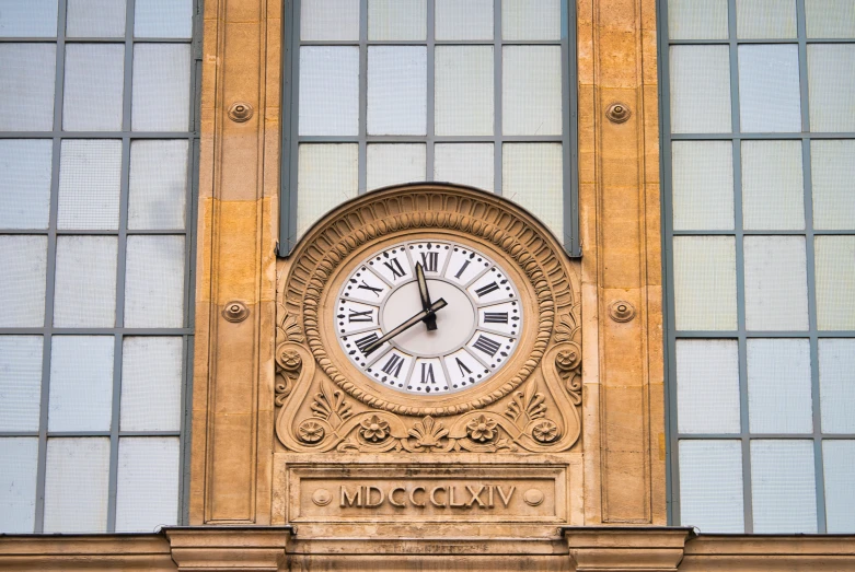 a large clock mounted to the side of a brick building