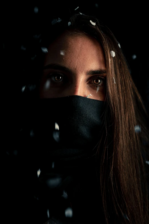 a woman wearing a face mask and veil covered in snow