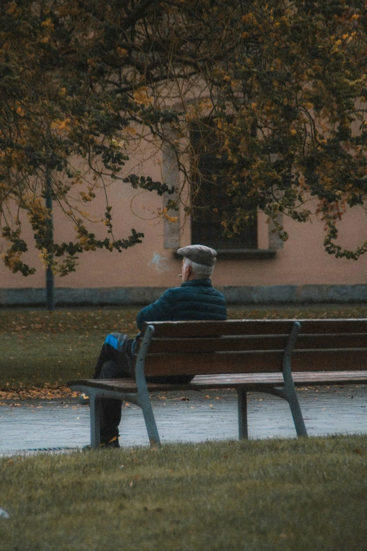 man sitting on bench next to a body of water