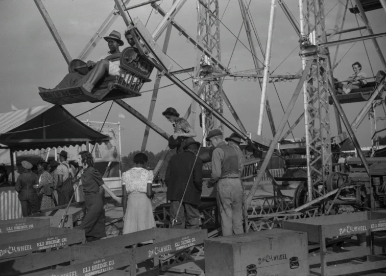 an old black and white po of people on a ferris wheel