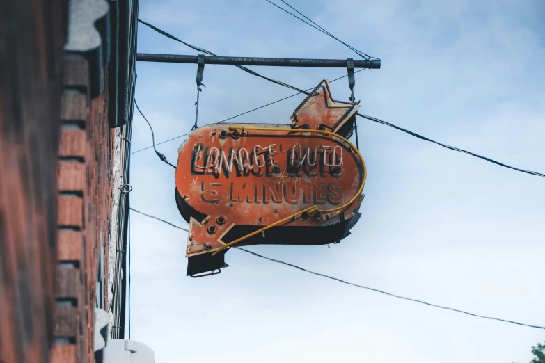 there is a rusty orange sign attached to the building