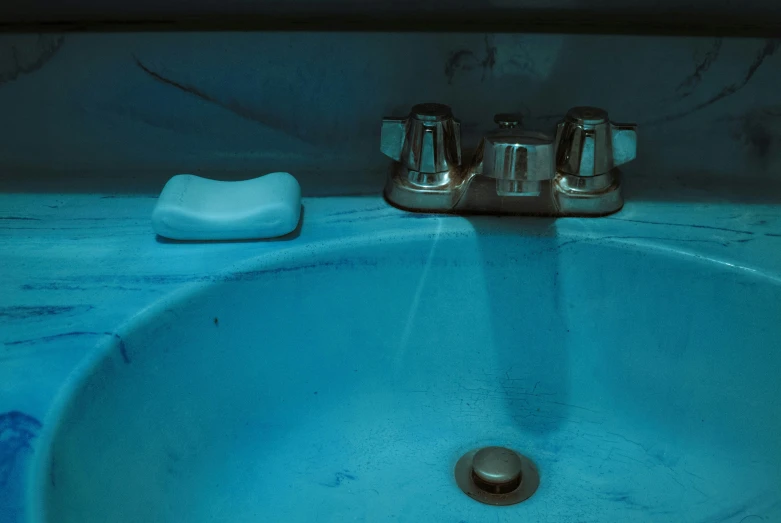 a bathroom sink with a blue and black counter top