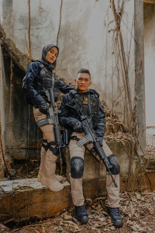 two people pose with their weapons in a military scene
