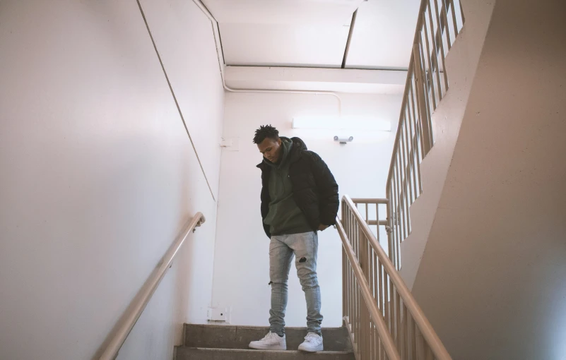 a person wearing white sneakers standing on the stairs