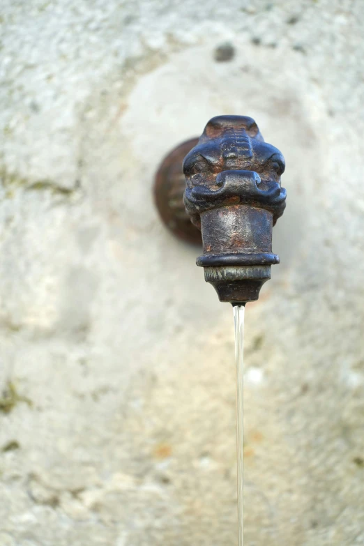 the old metal faucet is dripping water from it