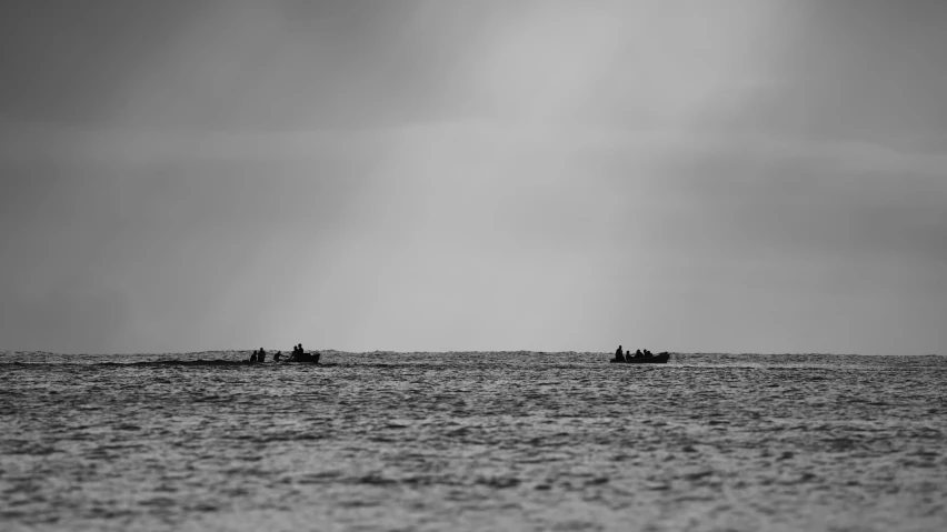 two people on small boats traveling in the ocean