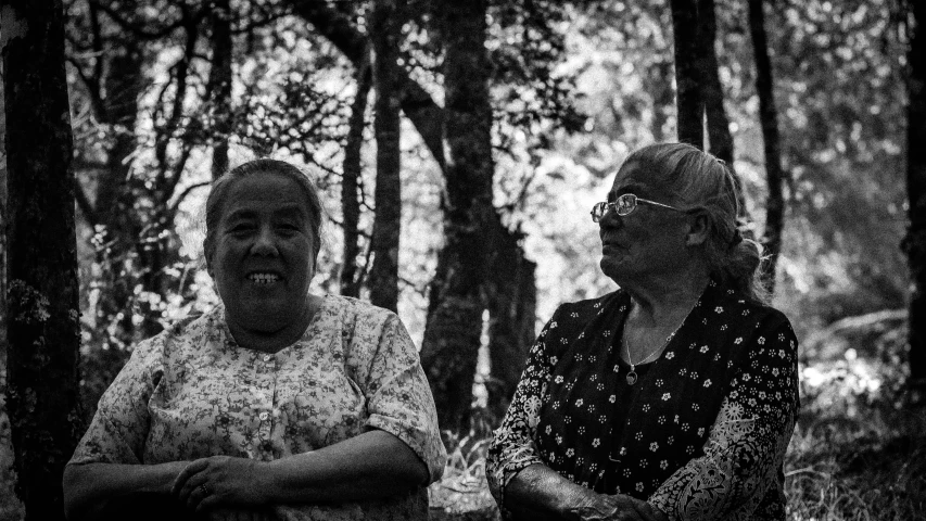 two women standing near each other in the woods