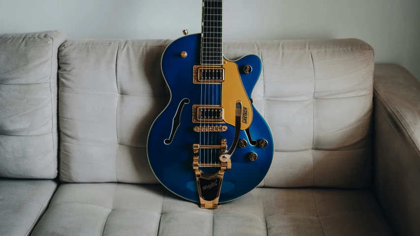 an electric guitar rests on the sofa