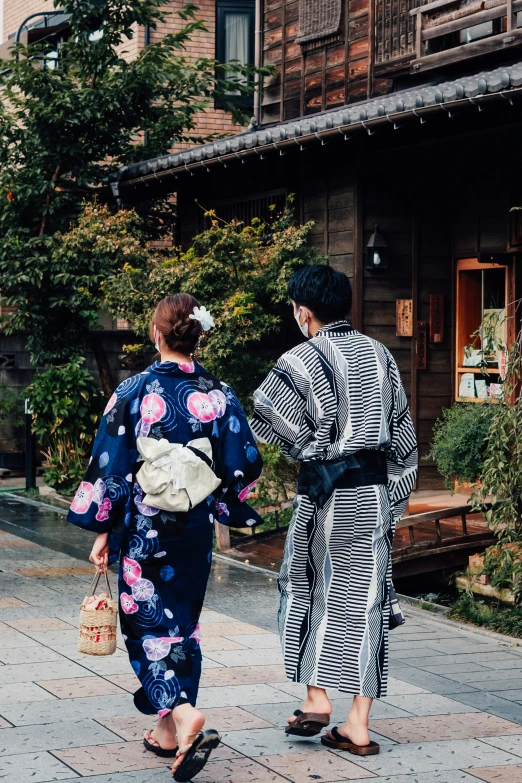 two women dressed in kimono are walking down the street