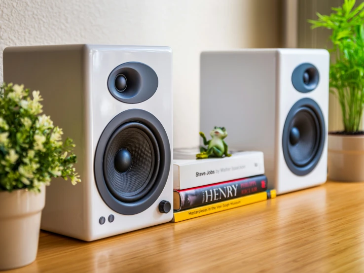 a small set of speakers sitting on top of a wooden desk