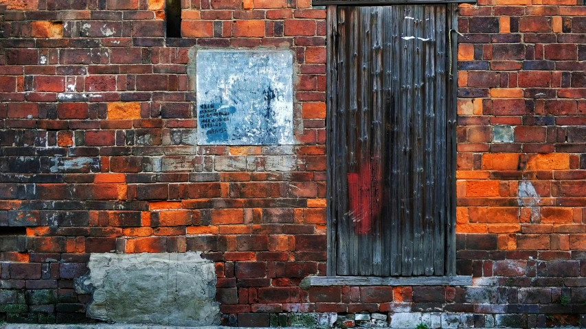 a rusted red brick building with boarded down window
