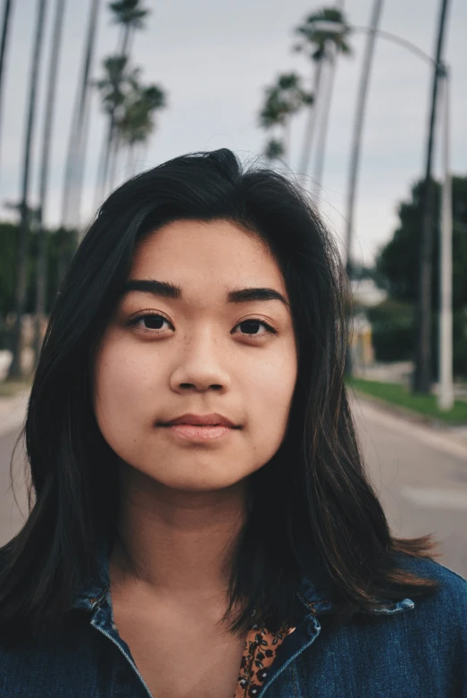 a woman that is standing in the street with palm trees