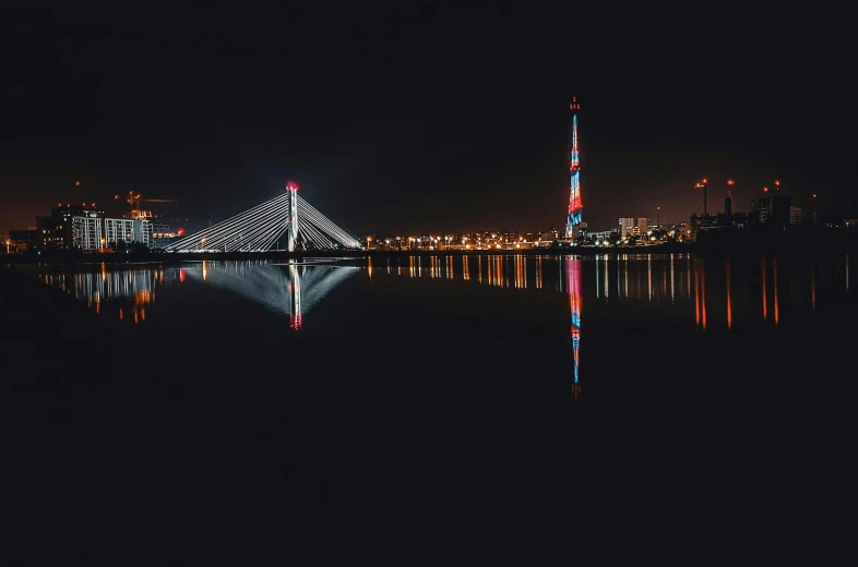 the reflection of lights in the water shows a city at night